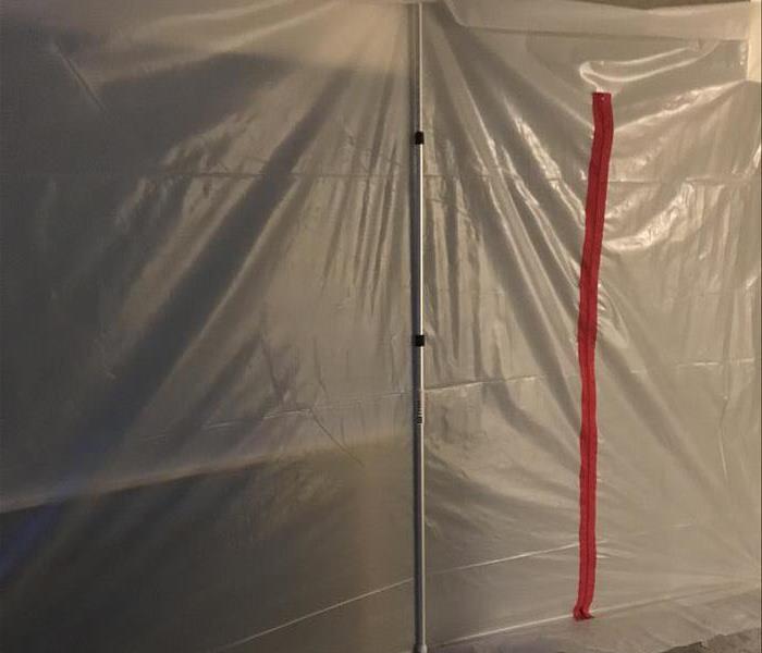 plastic tarp sealing room with red zipper 
