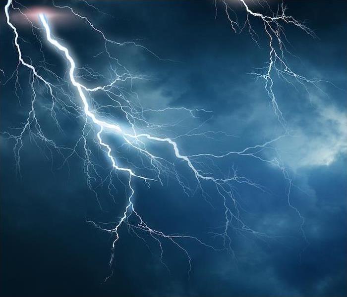 ”lightning.jpg” alt = "a large lightning strike off in the distance of a dark sky" >